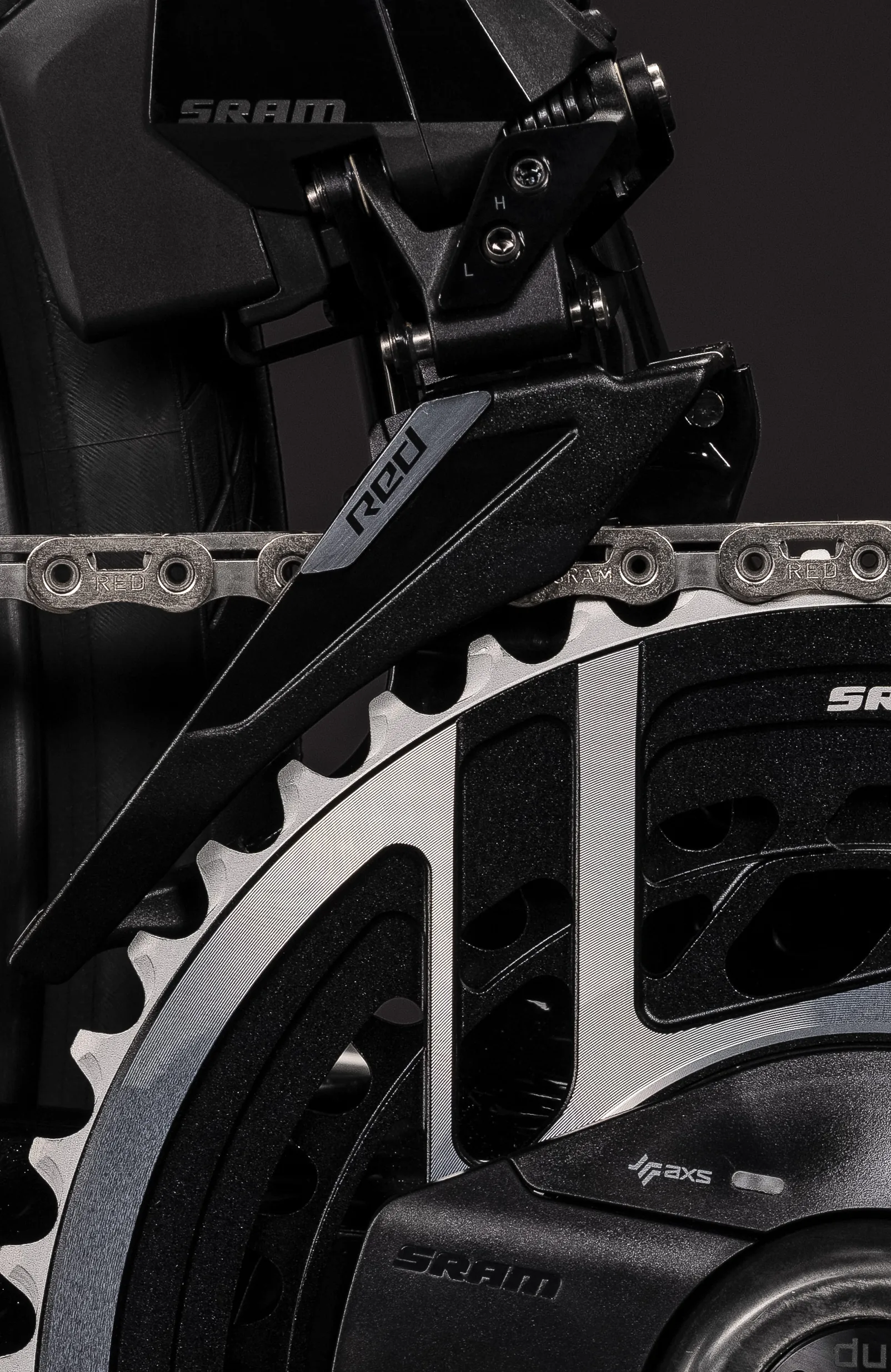 Umwerfer der SRAM-Red-AXS-Gruppe am CUBE Agree C:62 SLT AXS 2027 in blackpearl´n´switchwhite: die Schaltwange trägt den Schriftzug RED, davor Kettenblatt und Kette mit SRAM- und RED-Prägung