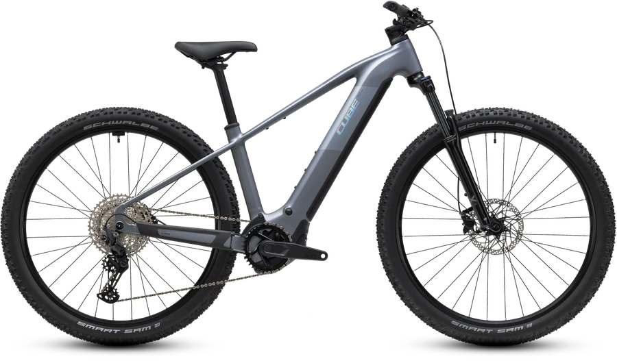 Cube Reaction Hybrid Performance 720 im Modelljahr 2027 in ashgrey´n´prism, freigestelltes E-Mountainbike in der Seitenansicht von der Antriebsseite, silbergrauer Aluminiumrahmen, Federgabel vorn, starrer Hinterbau, ohne Schutzbleche und Träger.