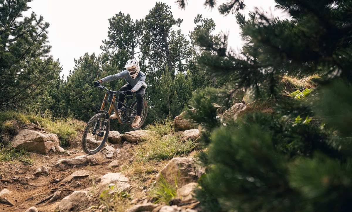 CUBE Mountainbike Fullys 2027: Abfahrt im Fullface-Helm über einen steinigen Trail zwischen Bergkiefern