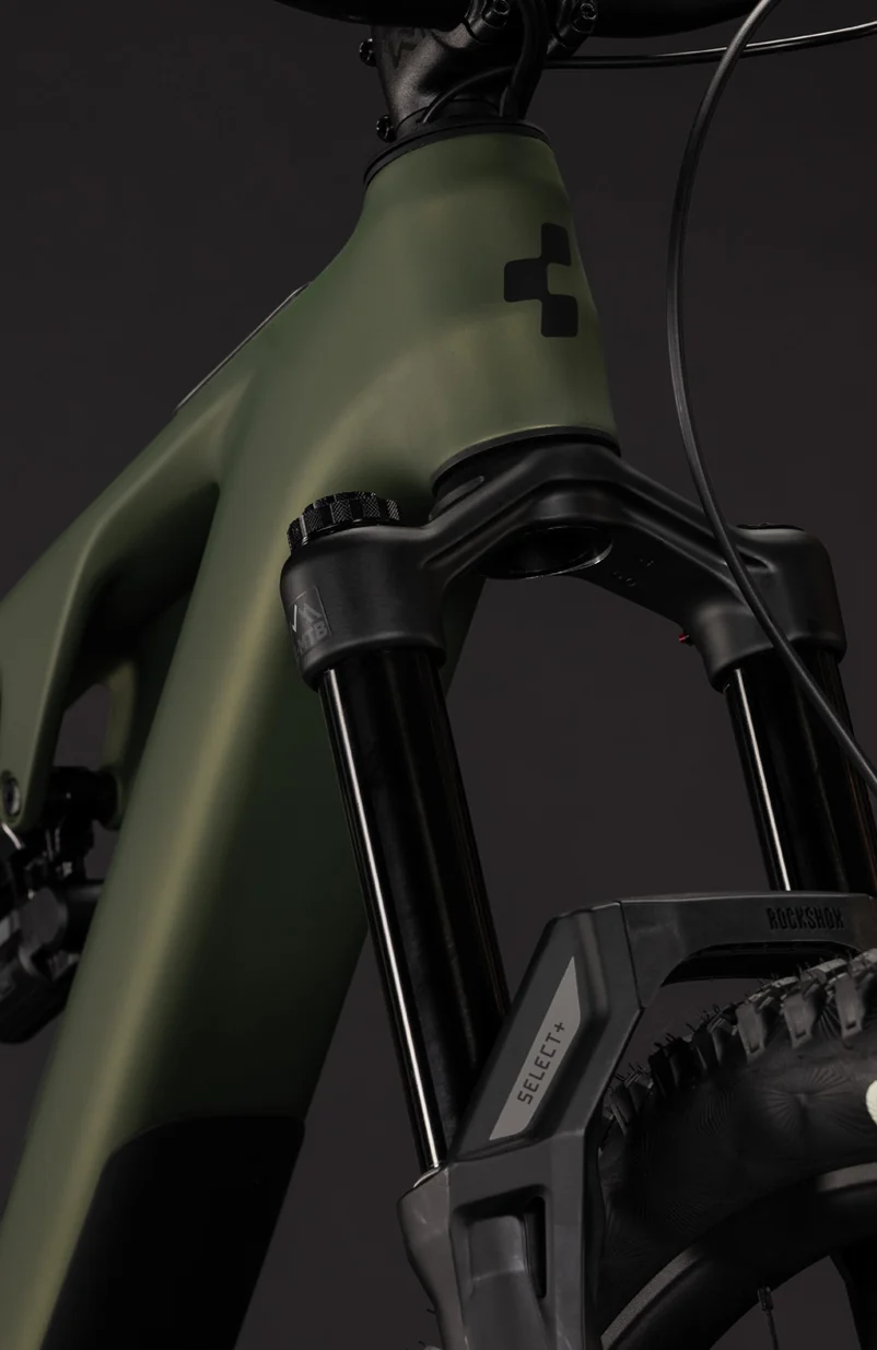 Vorderpartie eines CUBE AMS Hybrid 177 C:62 TM 2027 in reedgreen´n´gills: schwarze Federgabel mit dem Schriftzug SELECT+ am Gabelholm, dahinter der Stollenreifen, oben das Steuerrohr mit CUBE-Logo, Studioaufnahme auf dunklem Grund